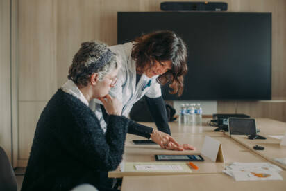 Atelier retour au travail avec une patiente assise et une soignante debout face à une tablette